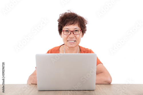 Фотография Old Chinese lady wearing glasses sitting in front of a laptop in front of a whit