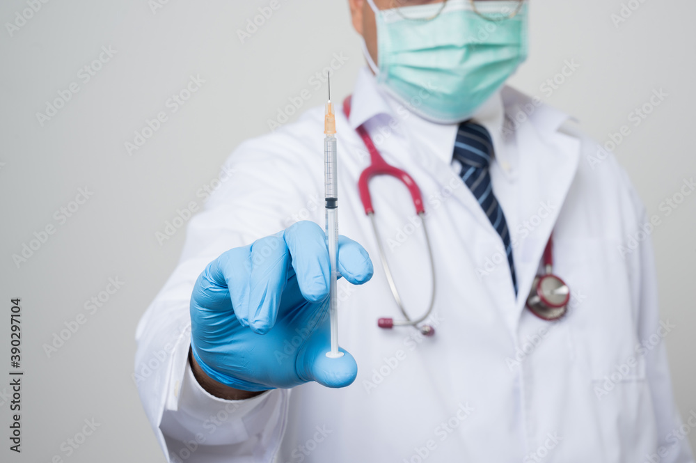Close Up Asian bald Doctor in white coat, stethoscope, blue glove showing a.syringe in front of camera isolated on white background. Close Up Asian bald Doctor in white coat, stethoscope, blue glove showing a.syringe in front of camera isolated on white background.