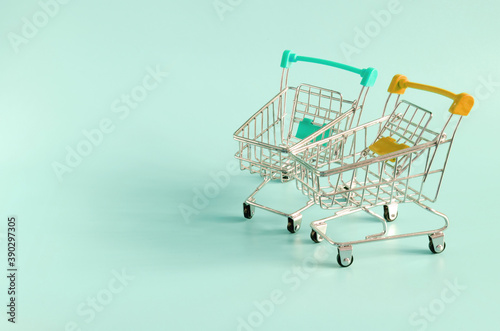 empty metal carts from the store on a colored background place under the text trade concept