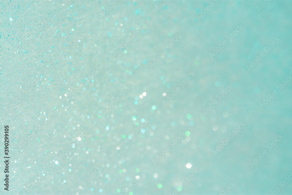 Abstract mint background with small sequins. The trending color of 2021. Bright greenish-turquoise shades. Christmas holiday shimmering background. Layout of a postcard or banner for the New year.