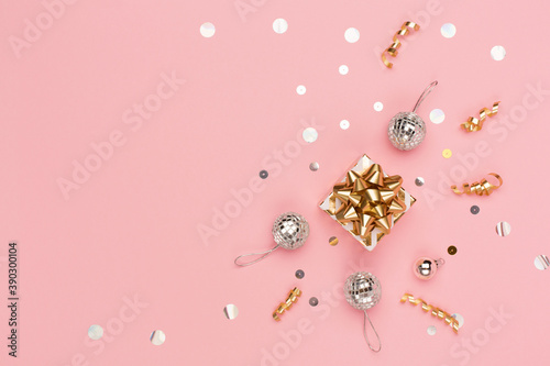 Christmas holiday greeting card template. Gold and silver decorations, festive gift box, mirror disco balls on pink background. © Iuliia Metkalova