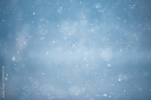 blue snowfall bokeh background, abstract snowflake background on blurred abstract blue © kichigin19