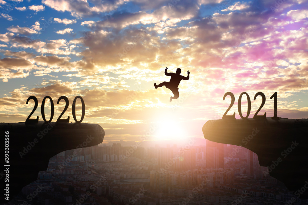 2021 concept: Silhouette of year 2021 on mountain  with city sunset  background