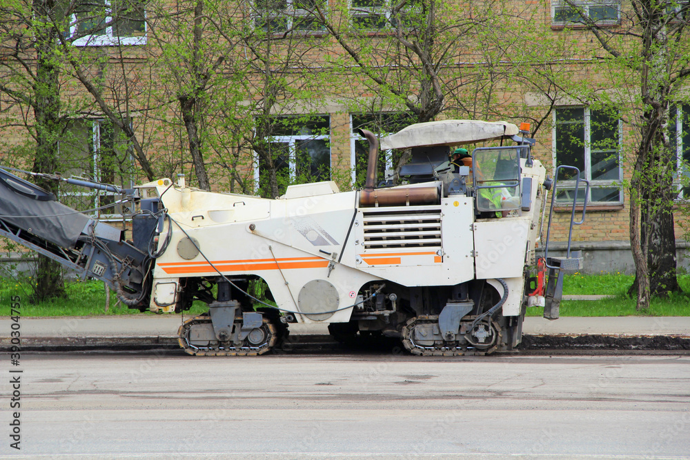 Special road equipment for laying asphalt on the street of the city in Russia. Repair work on the road in the spring