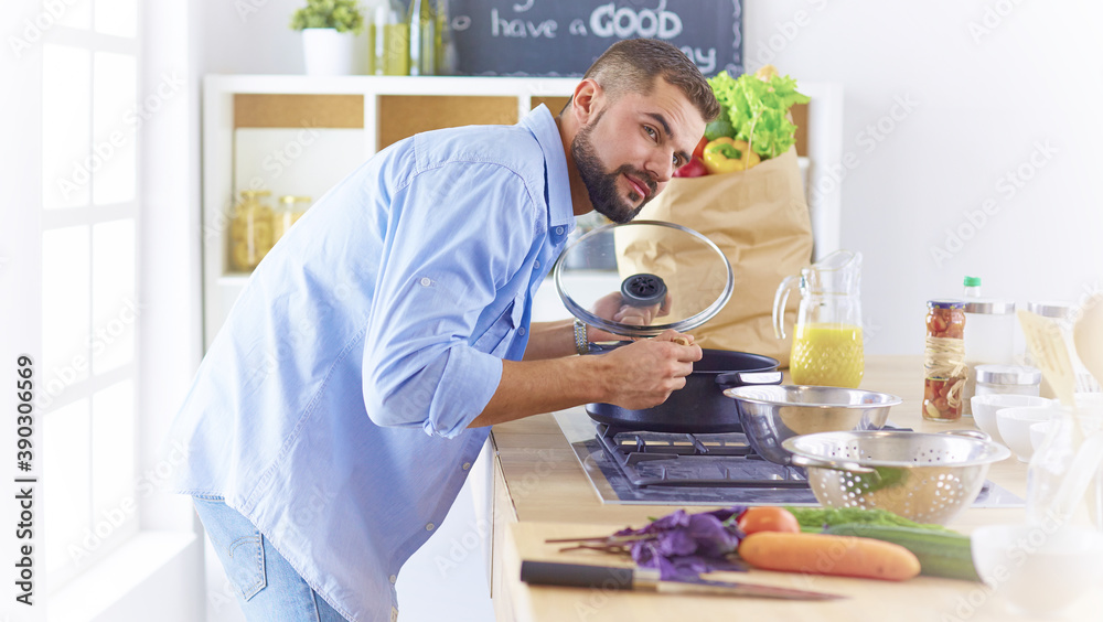 Smiling and confident chef standing in large kitchen Smiling and confident chef standing in large kitchen