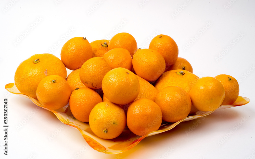 Tangerines in a large dish on a white background, close-up, copy space, isolated