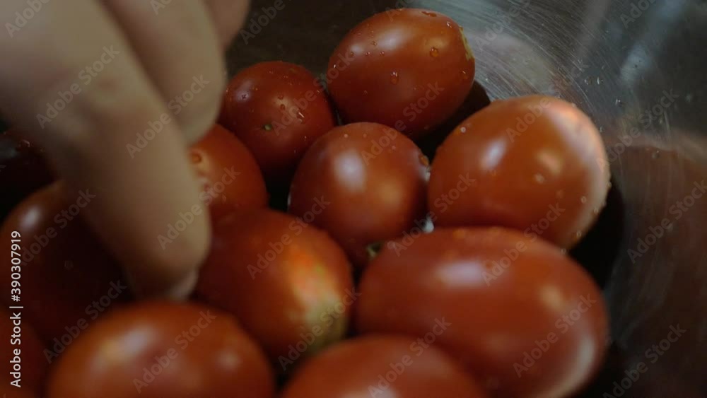 Baby tomatoes in bowl being pushed into shot and then some taken out. Baby tomatoes in bowl being pushed into shot and then some taken out.