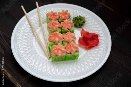 Set of eight sushi rolls on a white plate with salmon, eel, tuna, avocado, king prawn, cream cheese, tobiko caviar, Chuka. The sushi menu. Japanese cuisine. Top view of assorted sushi.
