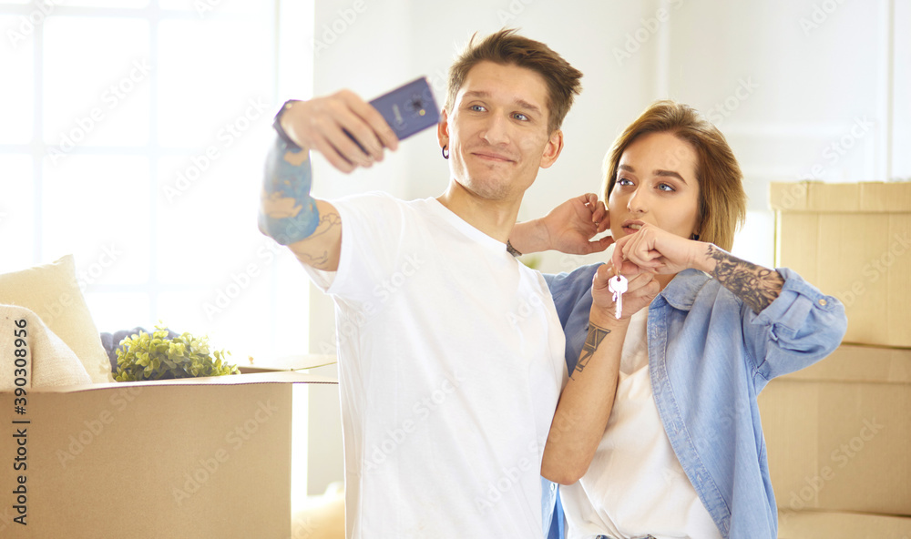 Happy smiling young couple showing a pair of keys of their new house Happy smiling young couple showing a pair of keys of their new house