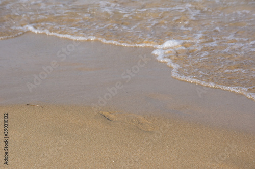 Sea surf, waves rolls on a sandy beach