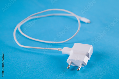 Isolated white charger on a blue background.