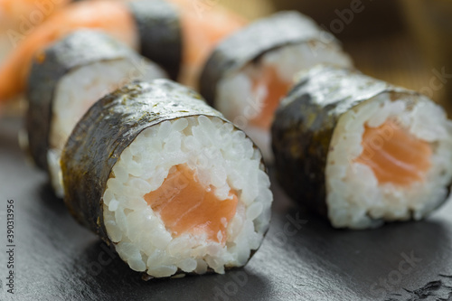 Closeup shot of sushi rolls and salmon nigiris on a board photo