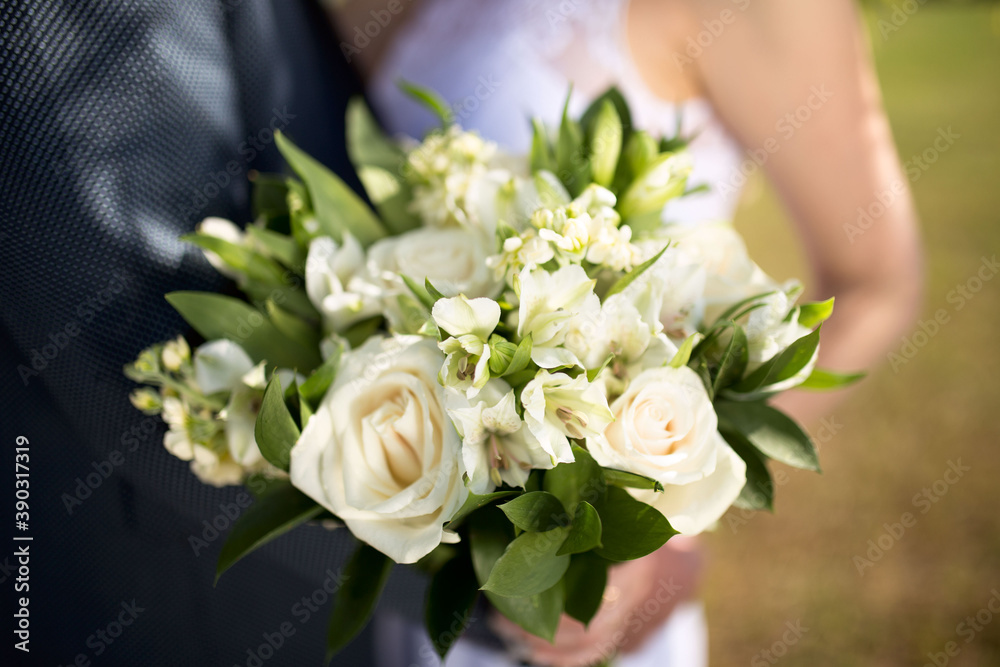 Big nice wedding bouquet in woman's hands. Bride and groom on their wedding hugging. Big nice wedding bouquet in woman's hands. Bride and groom on their wedding hugging.