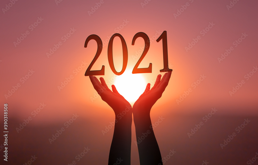 2021 concept: Hands hold 2021 against on sunset background 2021 concept: Hands hold 2021 against on sunset background