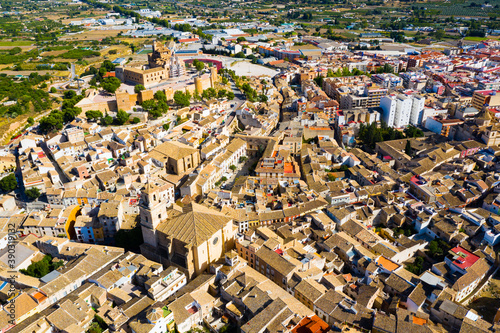 Scenic aerial view of residential areas and ancient Castle in small Spanish town of Caravaca de la Cruz on sunny autumn day..