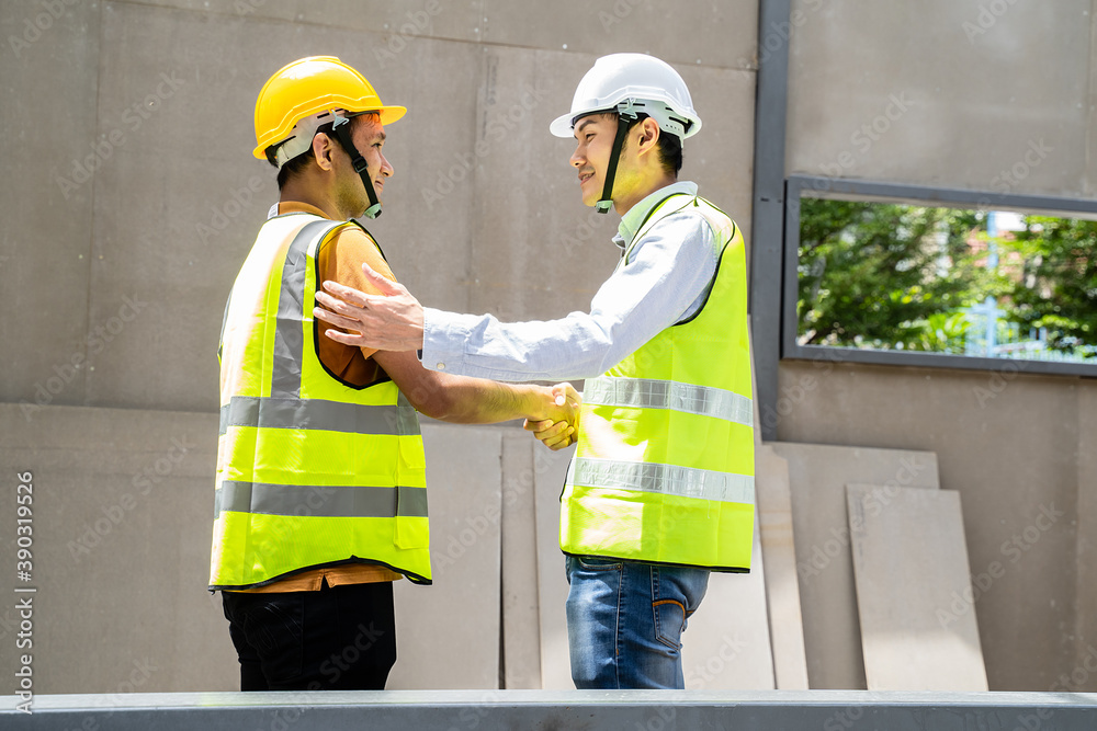 Asian structure engineer and worker making handshake at building site. Asian structure engineer and worker making handshake at building site.