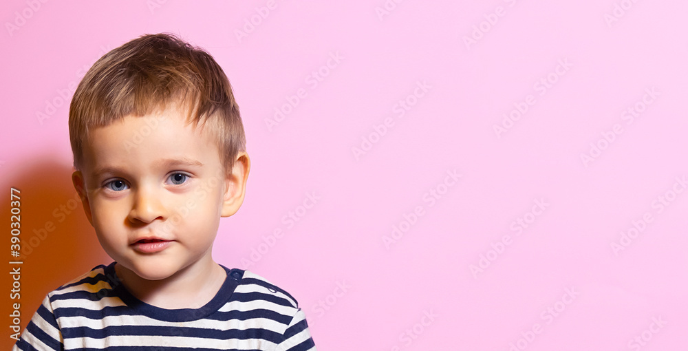 Blond Boy smart look a striped t-shirt on a pink background Blond Boy smart look a striped t-shirt on a pink background
