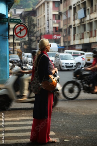Girl standing on a pedestrian crossing in the city of Panaji. State Of Goa. India. November 2020