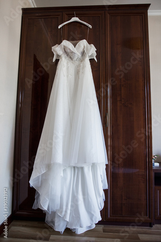 bride's wedding dress hanging on the wardrobe