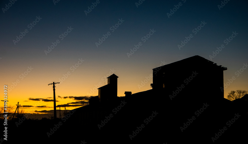 Agricultural buildings on the background of sunset
