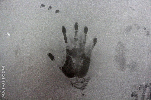 A handprint on the dusty wall.