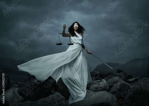 Young fairly woman with scale and sword over dramatic sky with copy space photo
