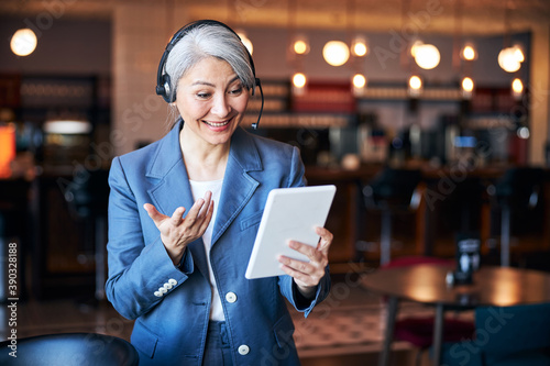 Cheerful woman in headphones using tablet computer