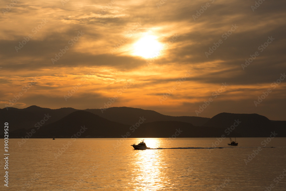 落日の海と船