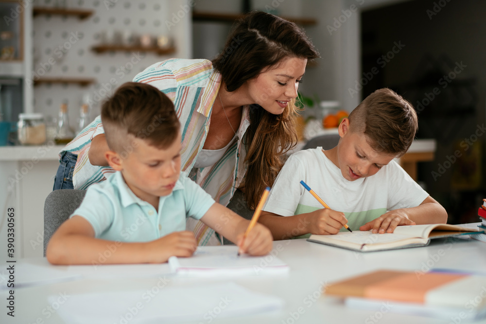 Mother helping her son with homework at home. Little boy learning at home.. Mother helping her son with homework at home. Little boy learning at home..
