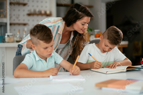 Mother helping her son with homework at home. Little boy learning at home..