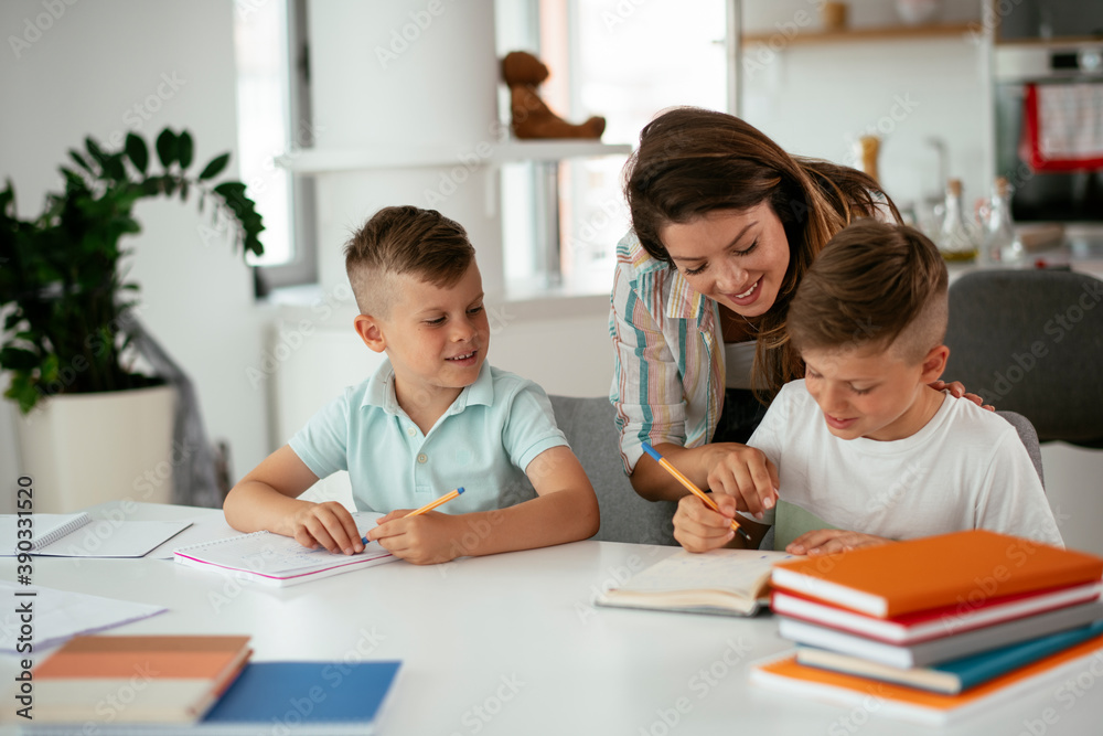 Mother helping her son with homework at home. Little boy learning at home.. Mother helping her son with homework at home. Little boy learning at home..