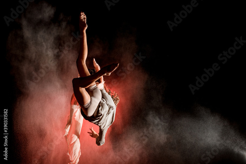 great view of woman perfectly jumps and performs trick upside down in the air at dark