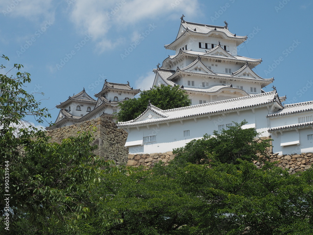 Ancient samurai castle in Himeji city in Japan with white walls, dark tile roofs and stone walls on a sunny day in summer with blue sky and white clouds Ancient samurai castle in Himeji city in Japan with white walls, dark tile roofs and stone walls on a sunny day in summer with blue sky and white clouds