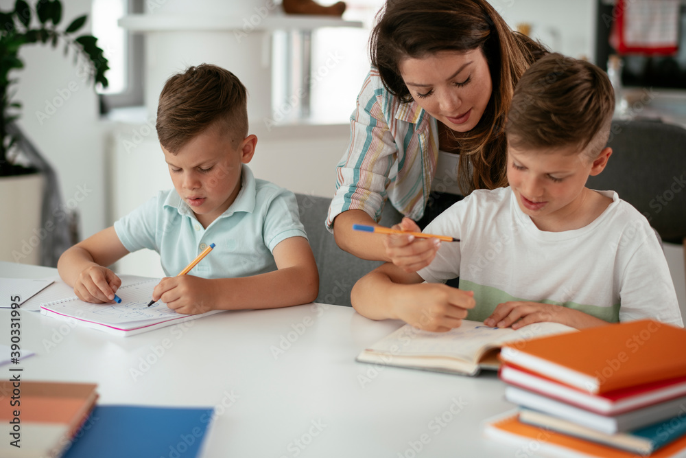 Mother helping her son with homework at home. Little boy learning at home.. Mother helping her son with homework at home. Little boy learning at home..