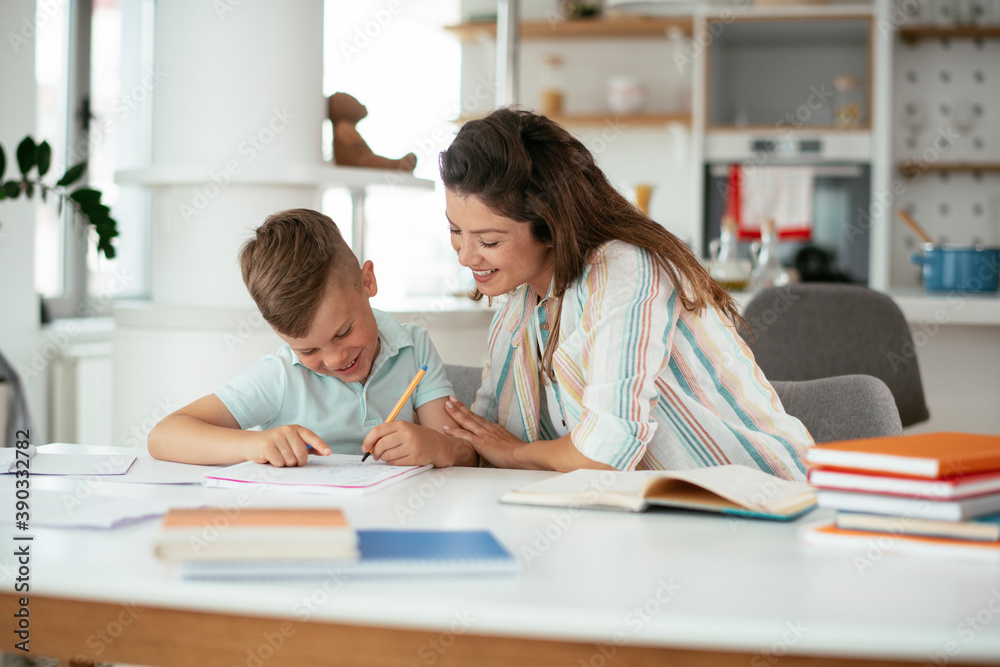 Mother helping her son with homework at home. Little boy learning at home.. Mother helping her son with homework at home. Little boy learning at home..