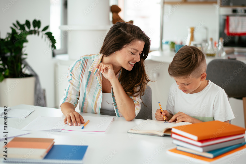 Mother helping her son with homework at home. Little boy learning at home.. Mother helping her son with homework at home. Little boy learning at home..