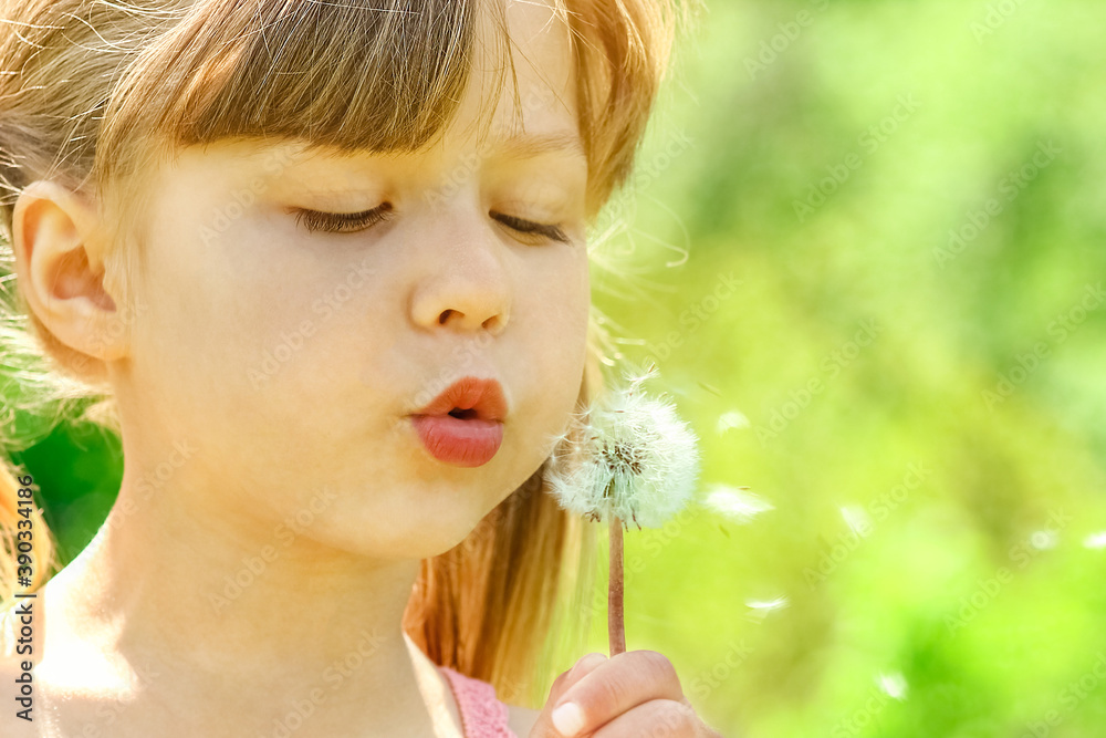 happy child playing and blowing dandelion in nature