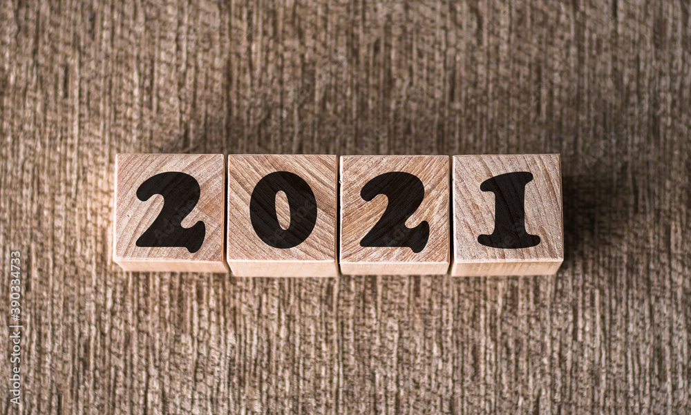 Fototapeta premium new year concept. font 2021 on wooden cubes on brown background for banner