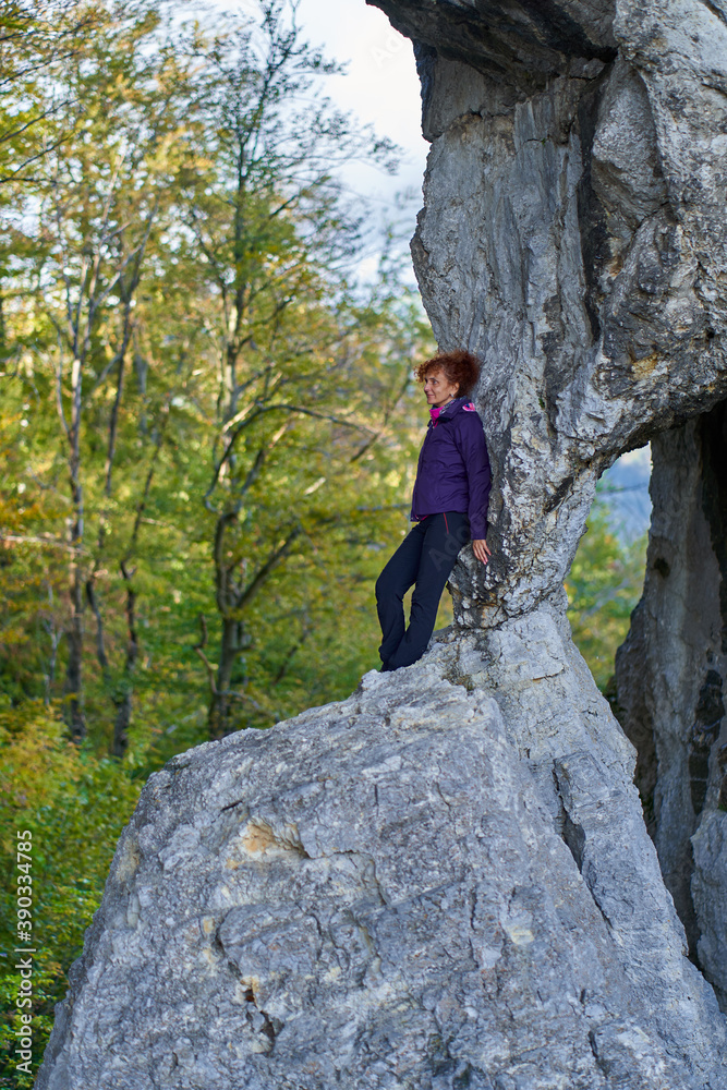 Obraz premium Woman hiker standing on the cliff in a doline