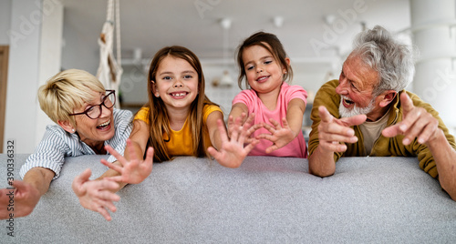 Grandchildren having fun, playing with grandparents at home
