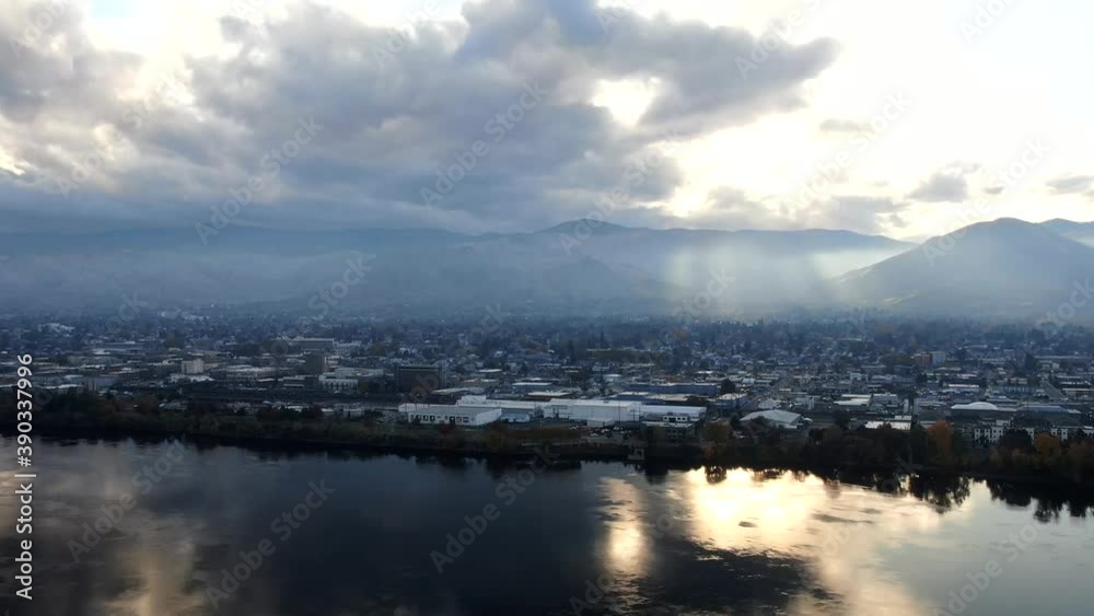 Drone Hyper-lapse on a foggy autumn river with hilly peaks and rays of sun cutting through the clouds leaving with a reflection. Drone Hyper-lapse on a foggy autumn river with hilly peaks and rays of sun cutting through the clouds leaving with a reflection.