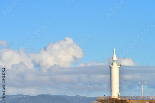 江の島の白い灯台のある防波堤の景色