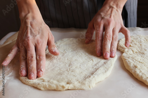 Household. A woman's hands form the dough for baking. Family celebration.