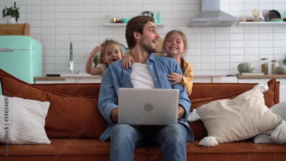 Caucasian male working from home with children, checking documents