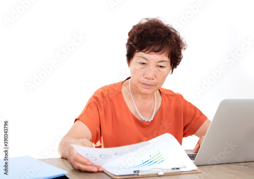 Middle-aged woman sitting in front of a laptop viewing financial documents