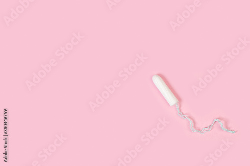 Un tampón femenino sobre un fondo rosa liso y aislado. Vista superior. Copy space