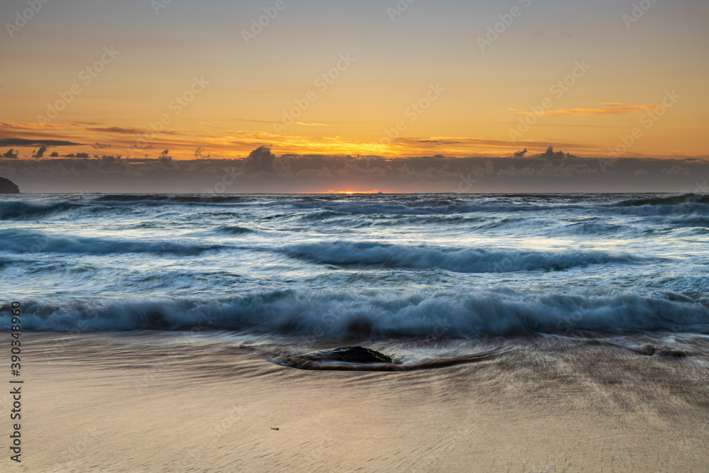 Sunrise seascape with light cloud, waves and rocks