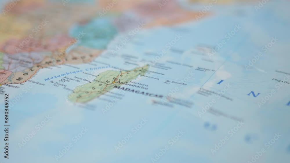 Person moving her finger around Madagascar and pointing at Africa on a map Person moving her finger around Madagascar and pointing at Africa on a map
