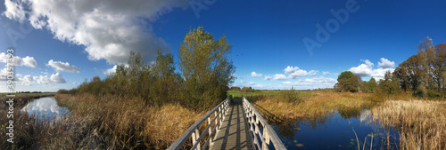 Panoramic from a bicycle path bridge over a canal in a nature reserve photo