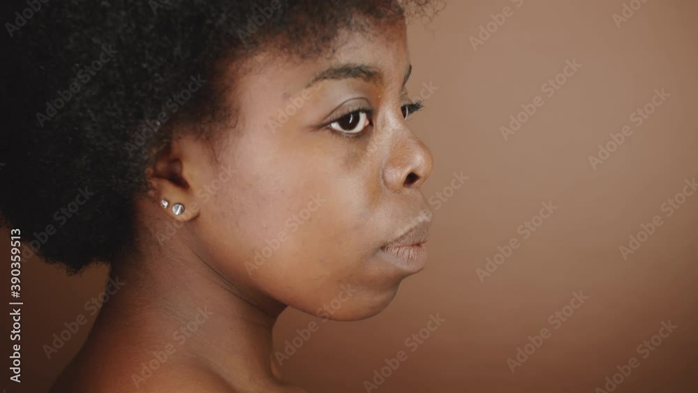 Profile shot of young beautiful African American female model looking away while posing in studio Profile shot of young beautiful African American female model looking away while posing in studio